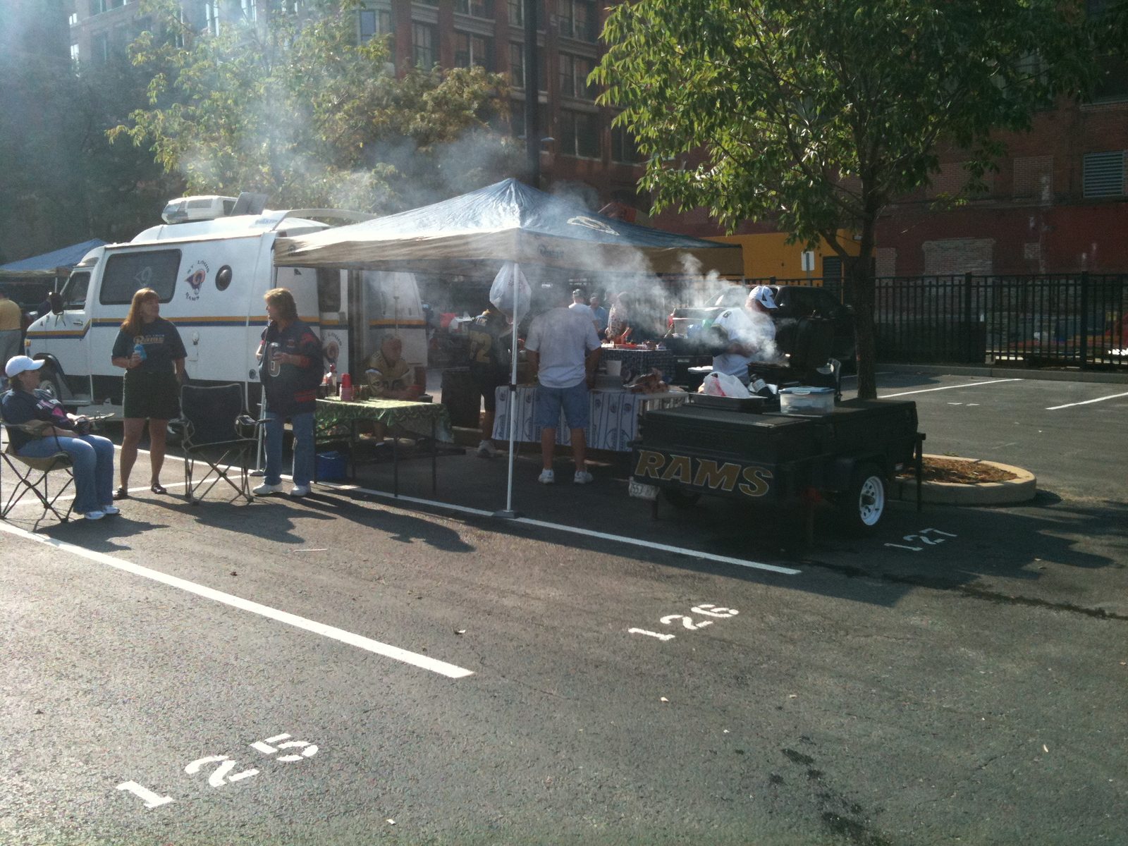 Smoke on the asphalt — trailer grill working under a canopy (ILTT archive)